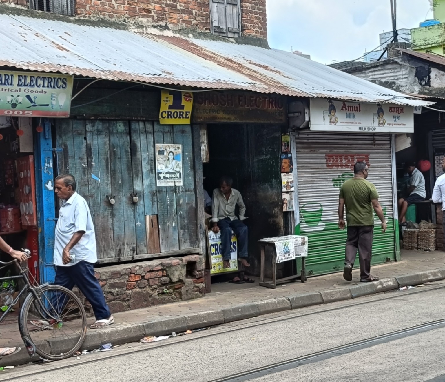 A shuttered old shop beside a modern transformed SuperKirana store